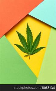 Decorative colorful frame from paper with marijuana leaf on an yellow background, copy space. Concept use of cannabis for medical puposes.. Geometric frame from colored paper with cannabis leaf.