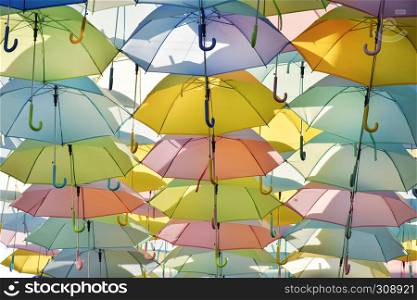 decorative colorful umbrellas hanging on walkway with clear blue sky