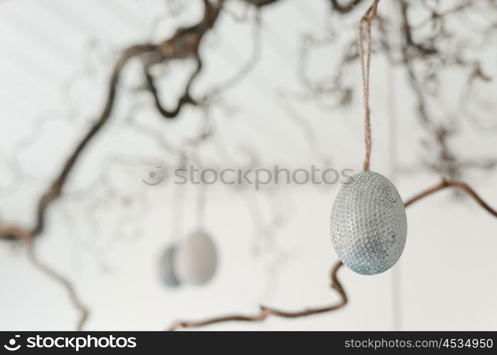 Decorative easter eggs hanging from a twig at easter