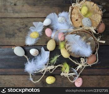decorative easter eggs painted with white feathers on wooden background