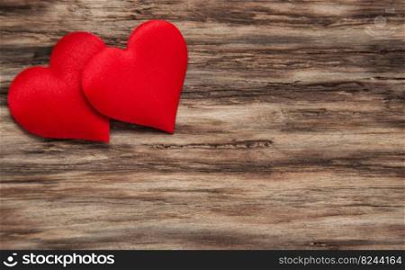 Decorative fabric hearts on a wooden background