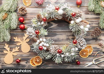 Decorative festive Christmas wreath. Wreath made of fir tree and co≠s on a old wooden background. Christmas decorations