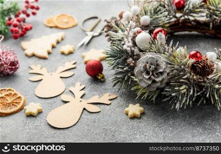 Decorative festive Christmas wreath. Wreath made of fir tree and cones on grey concrete background. Christmas decorations