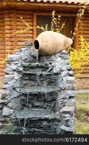 Decorative garden waterfall made with stone jar