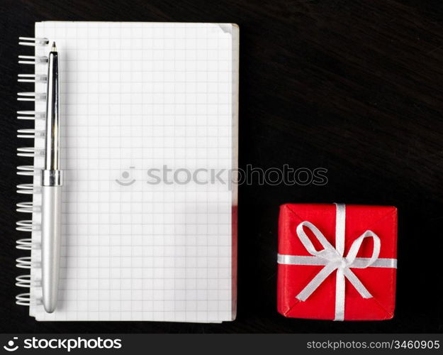 decorative gift box with notepad on dark table