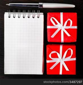 decorative gift boxes with notepad on dark table