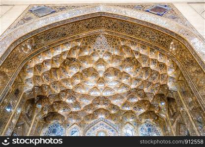 Decorative golden muqarnas vaulting with mirror work at the entrance of the Chehel Sotoun Palace. Isfahan, Iran.