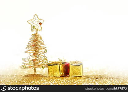 Decorative golden toy christmas tree and gifts isolated on white