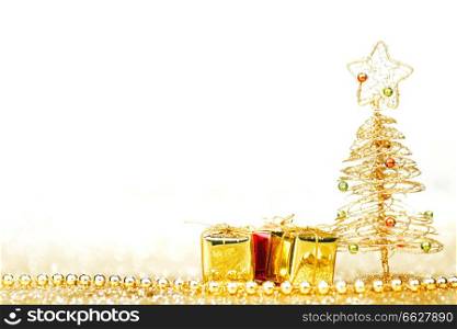 Decorative golden toy christmas tree and gifts isolated on white