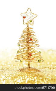 Decorative golden toy christmas tree on glitters isolated on white background
