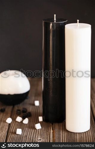 Decorative Handmade sphere and cylinder shape candles. Big black and white gift candles on the wooden background