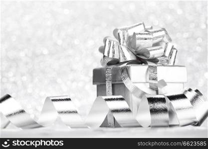 Decorative holiday Gift box and ribbon on bright shiny background