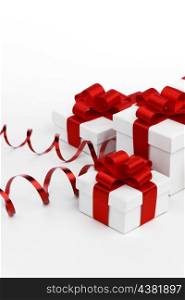 Decorative holiday gifts in white boxes with red ribbons on white background