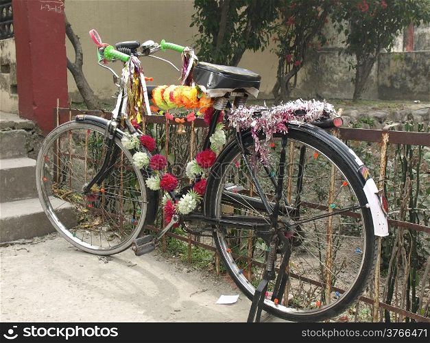 decorative old painted bicycle with basket of colorful flower fot puja in Rishikesh India