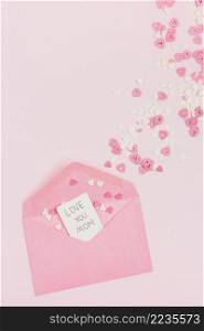 decorative paper hearts near envelope with tag with words
