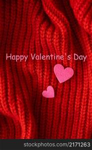 Decorative pink heart on a red knitted background, top view. Lettering Happy Valentine&rsquo;s Day. Decorative pink heart on a red knitted background, top view. Lettering Happy Valentine&rsquo;s Day.
