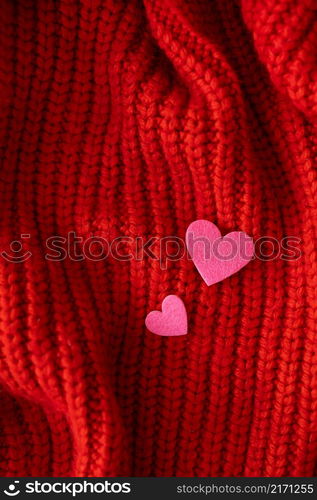 Decorative pink heart on a red knitted background, top view. Place for an inscription. Decorative pink heart on a red knitted background, top view. Place for an inscription.