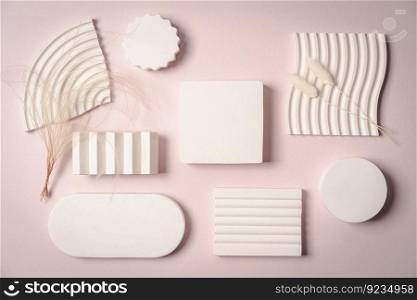 Decorative plaster podiums on pastel pink background, top view, flat lay. Place for product presentation. Creative product platform. Decorative plaster podiums
