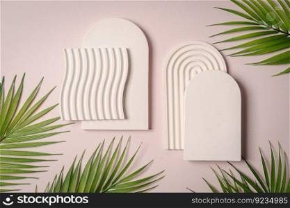 Decorative plaster podiums with palm≤aves on pastelπnk background, top view, flat lay. Place for∏uct presentation. Creative∏uct platform. Decorative plaster podiums