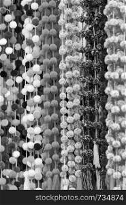 Decorative pom-poms hanging in a Chiapas market as a background texture in stunning black and white
