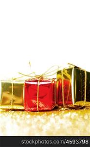 Decorative red and gold boxes with holiday gifts on shiny glitter background