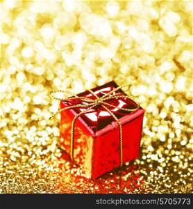 Decorative red box with holiday gift on shiny glitter background