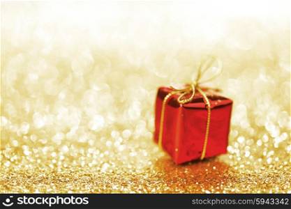 Decorative red box with holiday gift on shiny glitter background