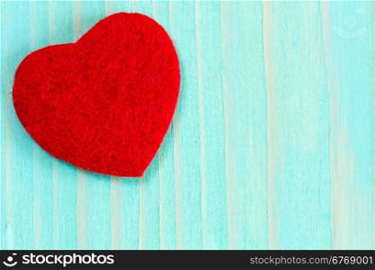 Decorative red heart on blue wooden background
