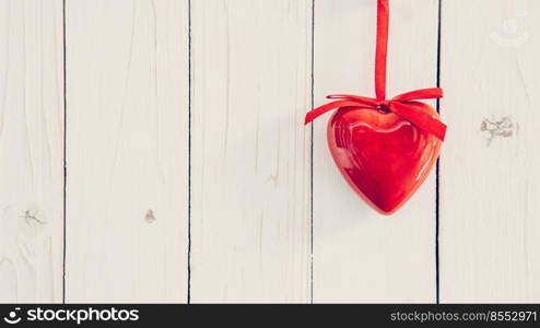 Decorative red hearts hanging on vintage wooden background with space. Valentine background.