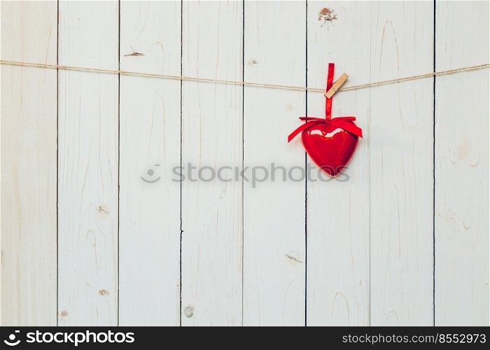 Decorative red hearts hanging on vintage wooden background with space. Valentine background.