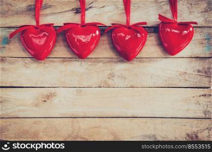 Decorative red hearts hanging on vintage wooden with space. Valentine background.