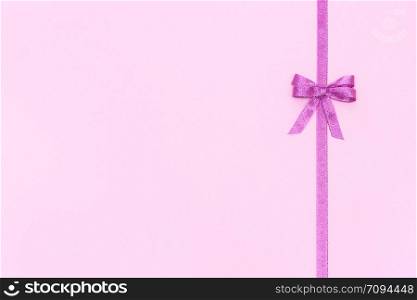 Decorative shiny ribbon with bow on pastel pink background with copy space for text, Top view, Layout.. Decorative shiny ribbon with bow on pastel pink background with copy space for text, Top view, Layout
