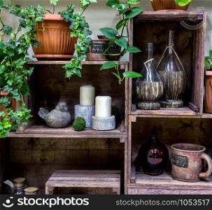 Decorative showcase made from wooden fruit boxes. Flower shop. Vintage composition with potted flowers, vases, candles and etc.. Decorative showcase made from wooden fruit boxes. Flower shop.