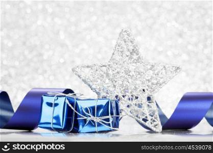 Decorative silver christmas star and gifts on glitter background