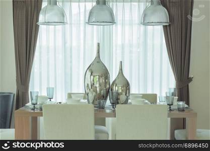 Decorative silver jars at center of dining table in modern classic style decoration