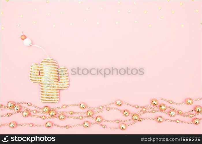 Decorative textile christmas toy cactus, golden garland and stars on pink background. Tropical Christmas or New Year night concept. Top view Creative flat lay Template for design, postcard.. Decorative textile christmas toy cactus, golden garland and stars on pink background. Tropical Christmas or New Year night concept. Top view Creative flat lay Template for design, postcard