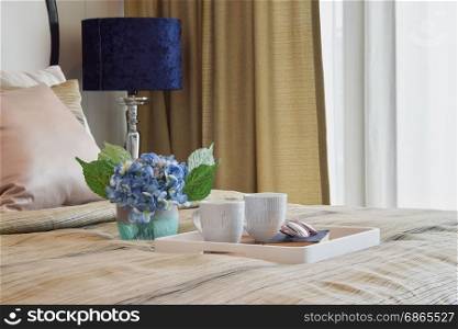 decorative tray of tea cup and book in stylish bedroom interior