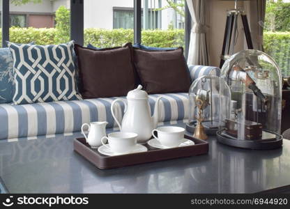 decorative tray of tea cup on wooden table in luxury living room interior