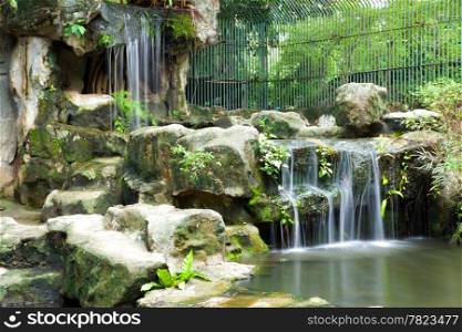 Decorative waterfall in the zoo. The serenity of the nature of the zoo.