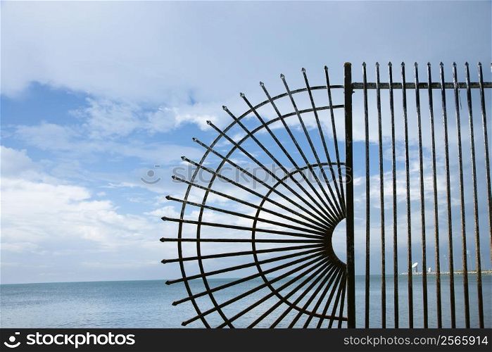 Decorative wrought iron fence at the edge of the sea.