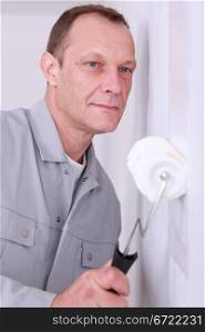 Decorator painting a room white