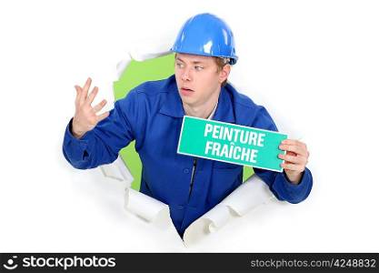 Decorator with a wet paint sign in French