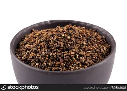 Decorticated cardamom seeds in a stone bowl on white background