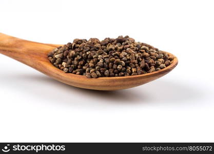 Decorticated cardamom seeds in a wooden spoon on white background