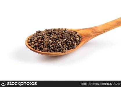 Decorticated cardamom seeds in a wooden spoon on white background