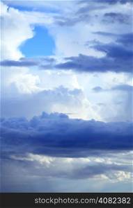 Deep blue sky background with storm clouds. Cloudy sky full of gray white thunder clouds before rain
