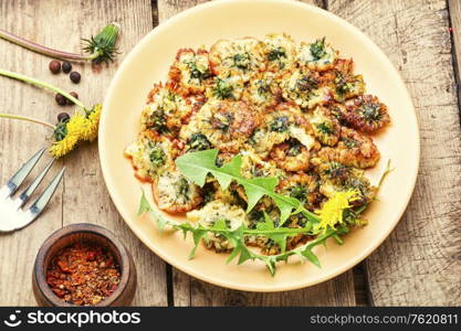 Deep fried dandelion flower on old wooden table. Deep frying dandelion