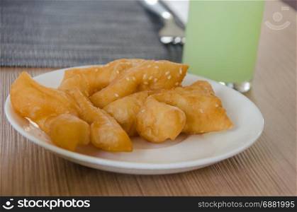 Deep fried dough stick on dish and guava Juice.