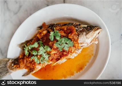 Deep Fried Fish with sweet and sour chili Sauce (Pla Rad Prik) top with cilantro Coriander - Thai traditional home cook food