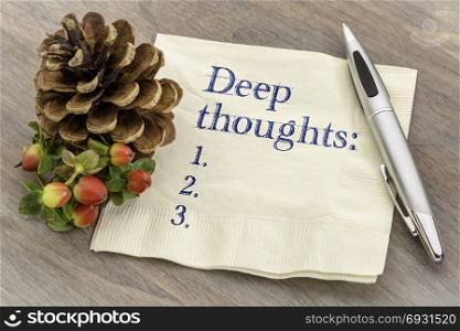 Deep thoughts list - handwriting on a napkin with a pine cone